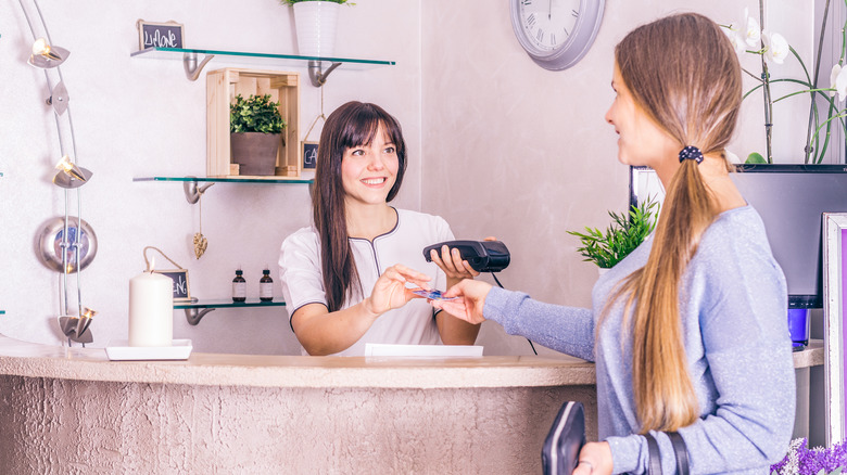 woman paying at salon