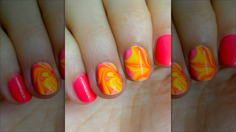 hands with marbled strawberry lemonade nails