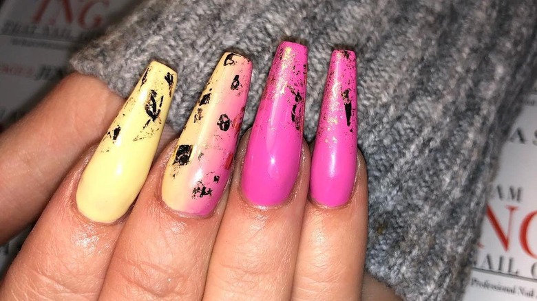 hand with pink yellow decal manicure