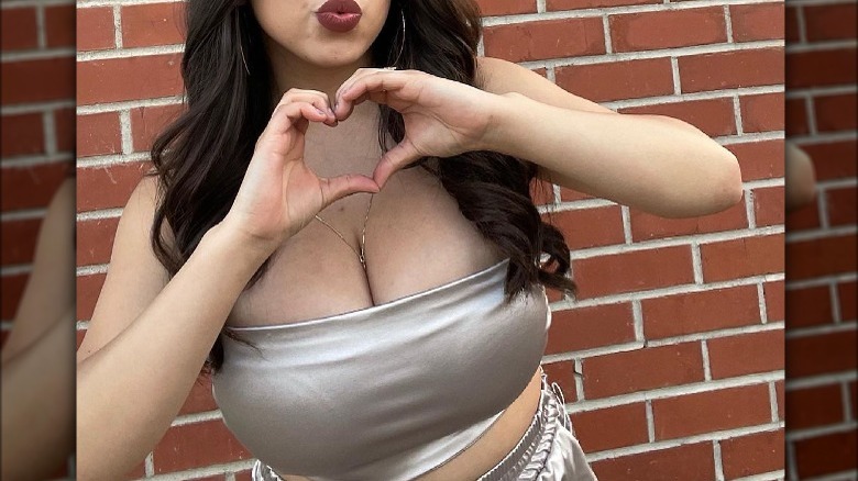 Woman making heart with hands in tube top