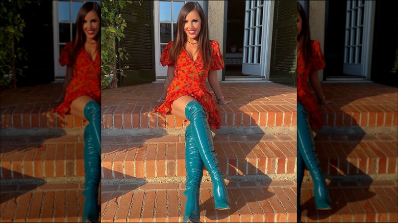 A woman wearing teal thigh high boots