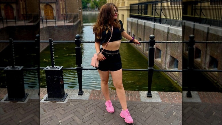 A woman wearing pink sneakers