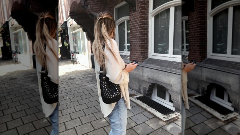 Girl wearing a studded hobo bag