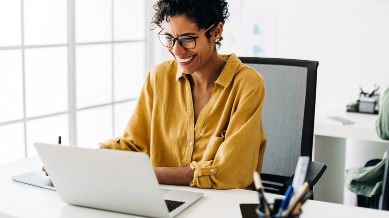 person smiling using laptop