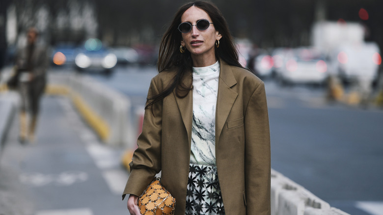 Woman intentionally dressed with olive blazer and statement yellow handbag