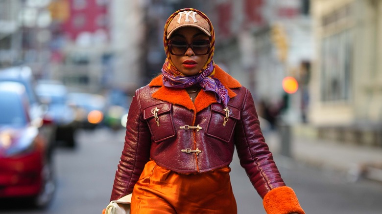 multi-colored scarf layered over neutral-colored baseball cap