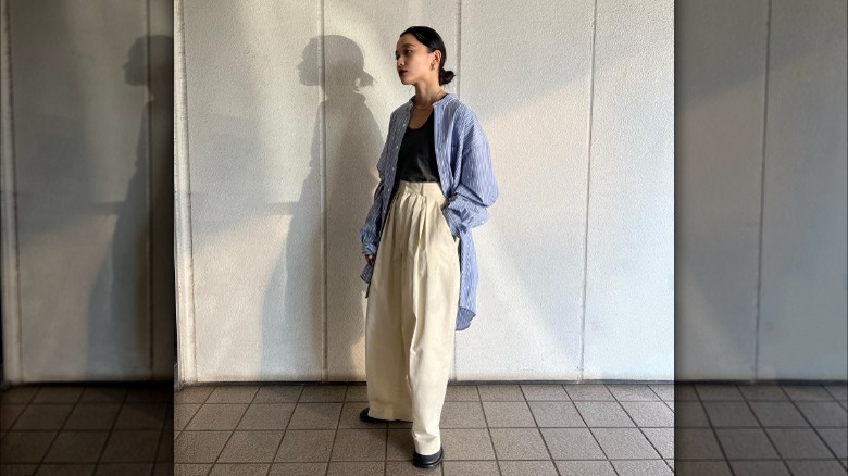woman wearing trousers and oversized pinstripe overshirt