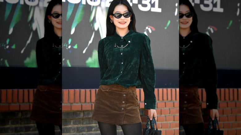 Woman wearing velvet blouse and corduroy skirt