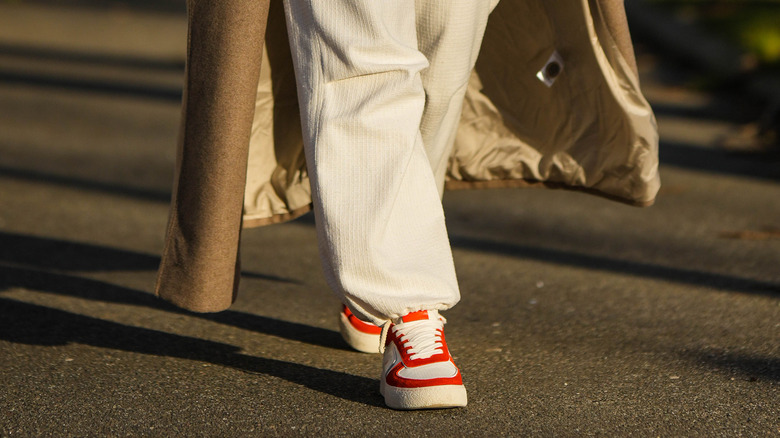 Woman wearing red and white sneakers