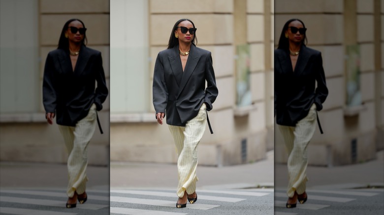 A woman wearing blazer and beige striped pants