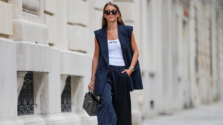 A woman wearing striped pants and a blazer.