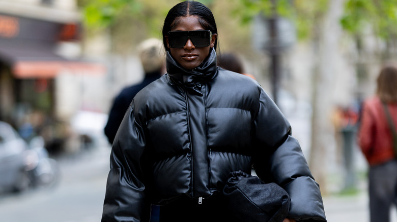 A person in a black puffer jacket and sunglasses.