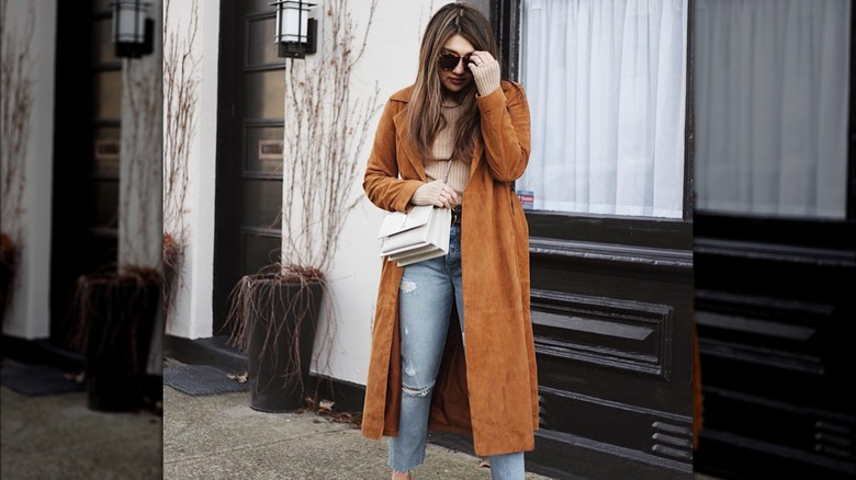 Girl wearing a longline suede coat.