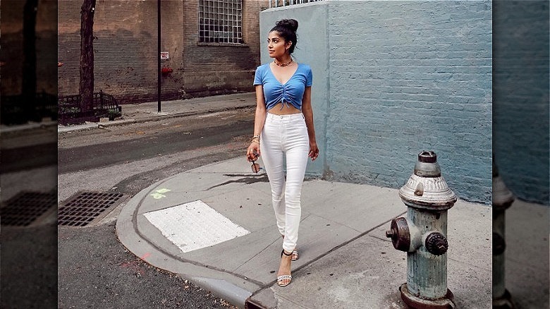 woman wearing bright white pants crop top