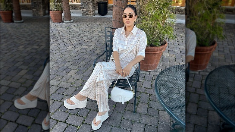 Woman wearing white platform flip-flops