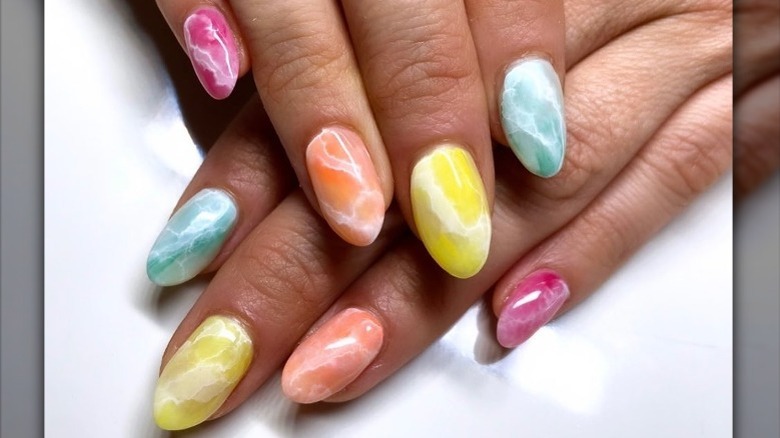 Hand with skittles-inspired manicure