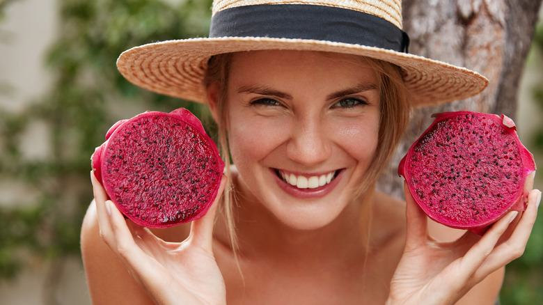 Woman holds dragon fruit 