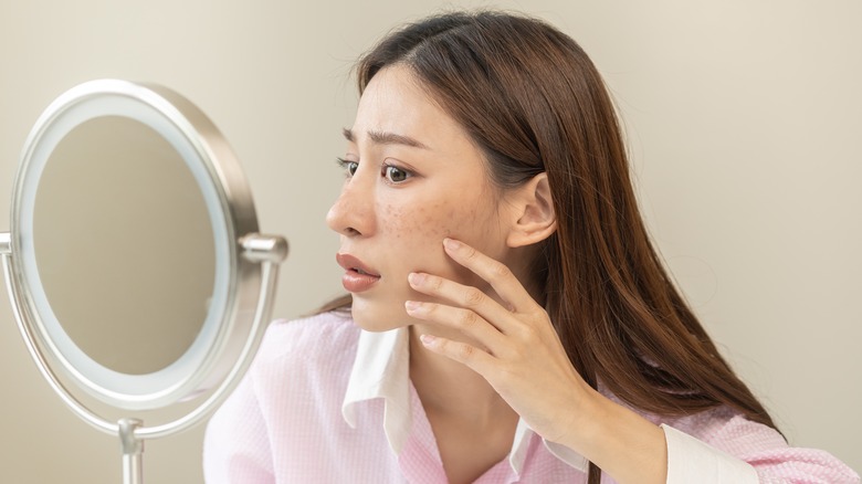 woman looking in makeup mirror