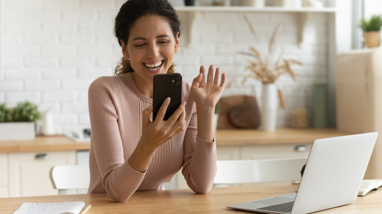 Woman laughing looking at phone