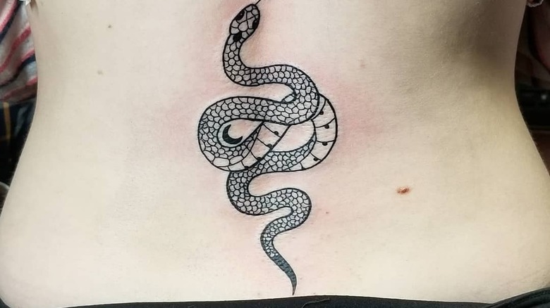 snake lower back tattoo