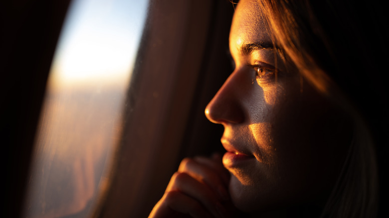 Woman looking out airplane window