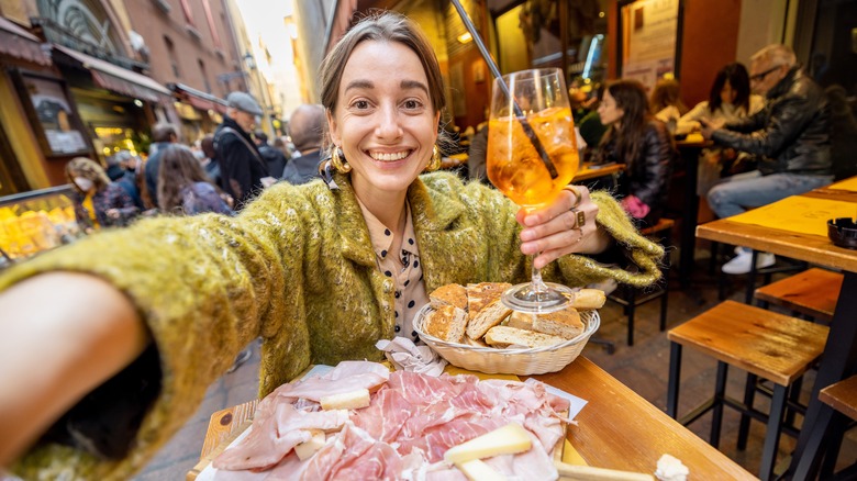 woman taking a selfie in busy restaurant