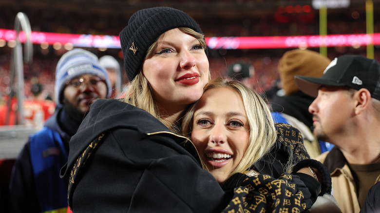 Taylor Swift and Brittany Mahomes hugging at a Kansas City Chiefs game.