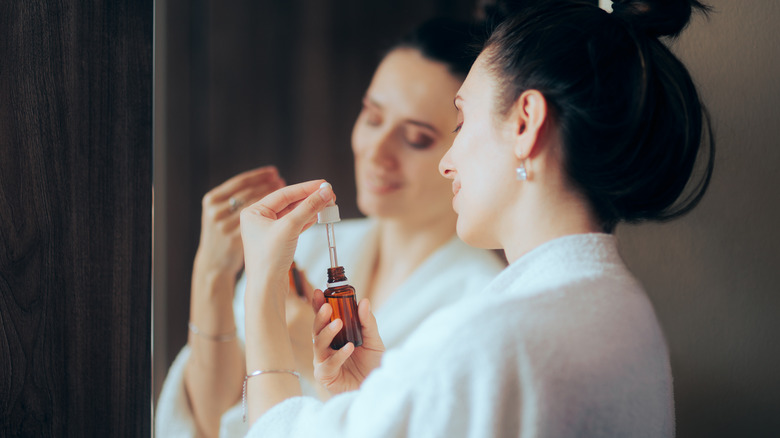 woman holding tea tree oil dropper