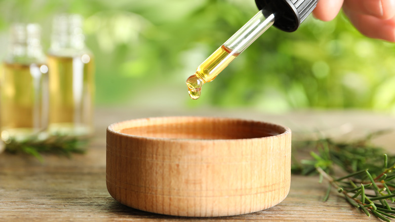 hand dripping tea tree oil into a bowl