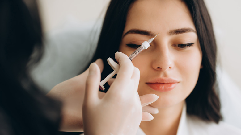 woman getting cosmetic injection between brows