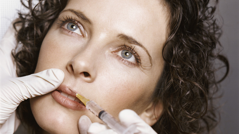 woman looking up getting lip injections