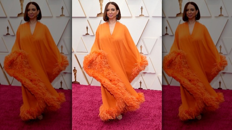 Actress wearing orange tent dress with feathers