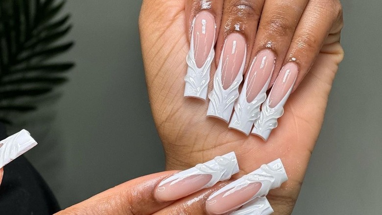 hands with white textured French tips