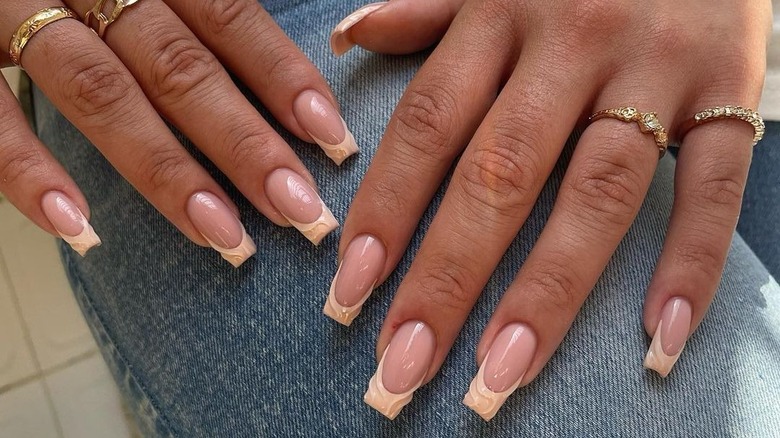 neutral textured French nails on jeans