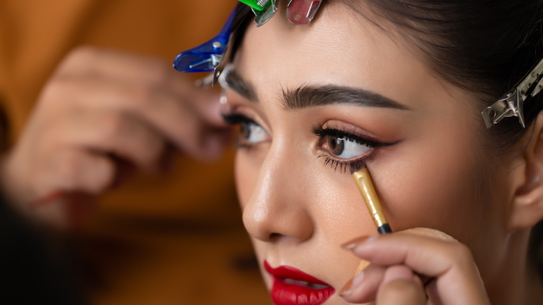 makeup artist applying waterline eyeliner