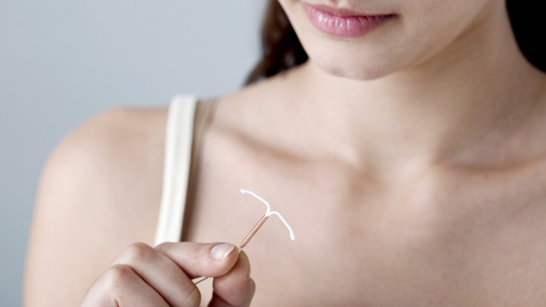 woman holding IUD