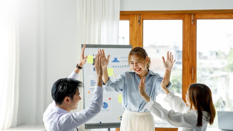 Co-workers high-fiving one another