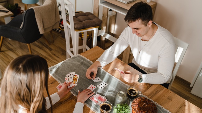 Couple playing cards at table