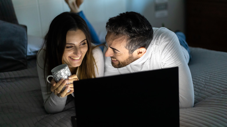 Couple watching show in bed