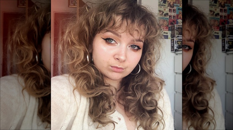 woman with curly bangs on shaggy hair