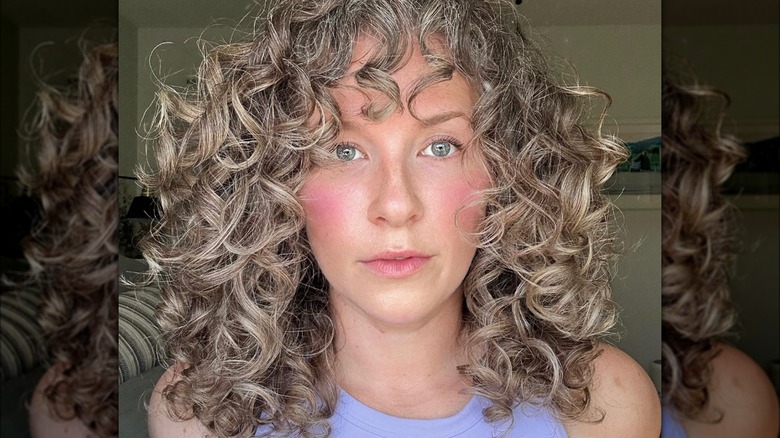 woman with face framing curl bangs