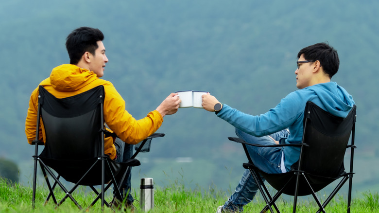 two men drinking coffee outdoors