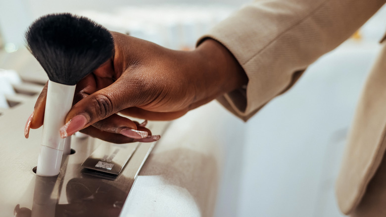 Woman reaching for makeup brush