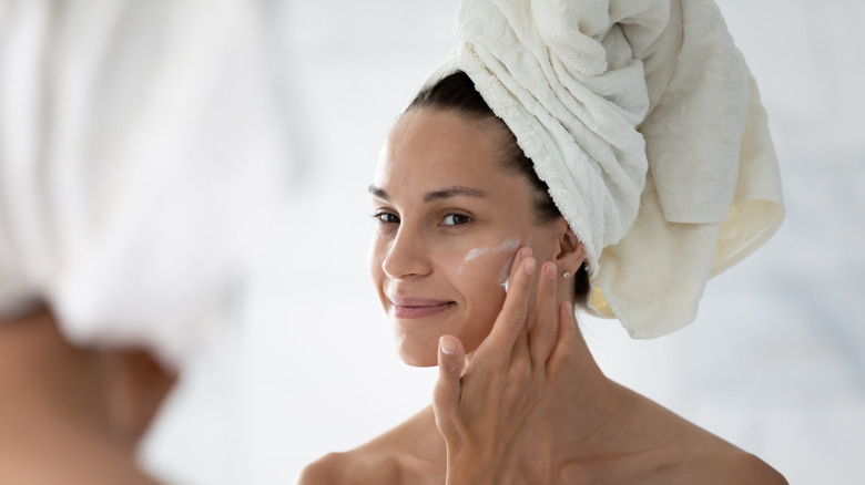 Girl applying cream on face