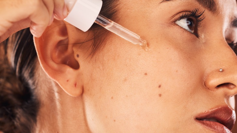 woman applying hyaluronic serum