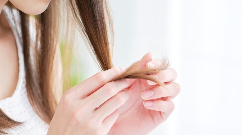 Woman analyzing ends of hair 