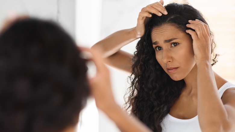 Concerned woman looking in mirror 