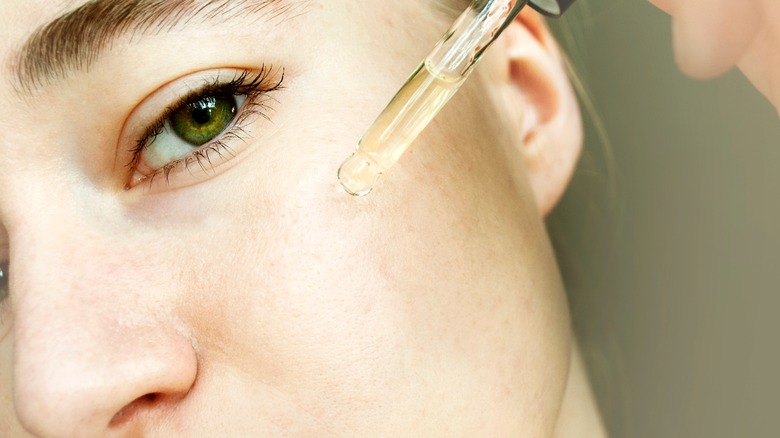 Woman applying tea tree oil