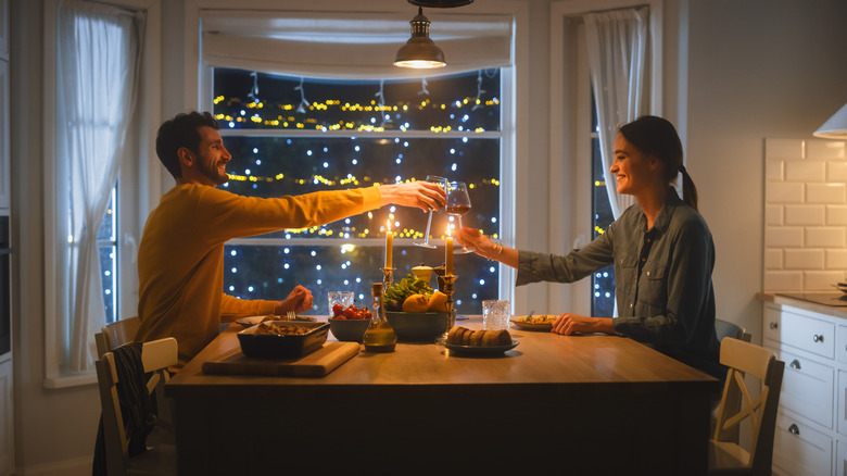 couple clinking wine glasses at dinner