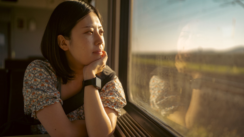 Thoughtful woman looking out train window